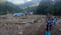 Sejumlah warga korban banjir bandang membawa barang-barang yang masih diselamatkan di desa Sapan Salak Kecamatan Koto Parik Gadang di Ateh, Kabupaten Solok Selatan, Sumatera Barat, Senin (25/11/2019). ANTARA FOTO/Muhammad Arif Pribadi.