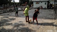Beberapa anak bermain sepakbola di sekitar rusunawa yang sedang direvitalisasi.