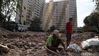 Beberapa warga mengumpulkan besi-besi sisa bangunan rusunawa.