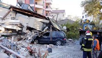 Sebuah mobil tertimpa reruntuhan bangunan. AP Photo/Hektor Pustina