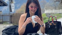 Santai sambil menikmati minuman di Swiss jadi pilihan liburan Helena. Tampaknya ia juga hobi fotografi karena di depannya sudah ada kamera. Foto: instagram @helenalim899