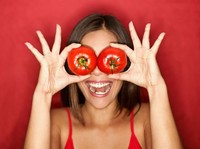 Tomato. Woman showing tomatoes holding them in front of eyes. Fresh energetic funny image on red background. See more