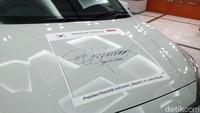 Penandatanganan dilakukan Jokowi di atas kap mobil.