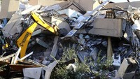 Ekskavator dikerahkan untuk mencari warga yang terjebak di reruntuhan bangunan. AP Photo/Hektor Pustina