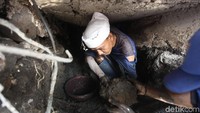 Pengerukan lumpur dilakukan dengan alat seadanya.