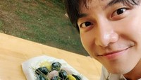 Lee Seung Gi pun memamerkan senyumnya yang manis saat berfoto bersama kue beras khas Korea. Foto: Instagram