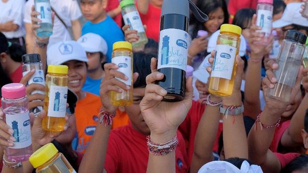 MENGATASI SAMPAH PLASTIK Di PULAU DEWATA Warga menunjukkan tumbler atau botol minuman dalam acara Indonesia Bersih Melalui Gerakan Satu Juta Tumbler di kawasan Pantai Matahari Terbit Sanur.