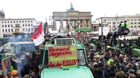 Ribuan petani nampak melakukan aksi protes terkait kebijakan pertanian pemerintah di depan Gerbang Brandenburg, Berlin, Jerman. Bernd von Jutrczenka/dpa via AP