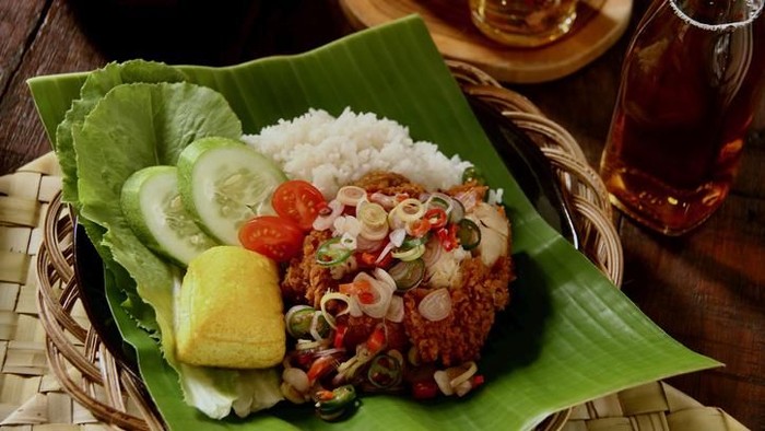 Sambal Matah, a popular salsa condiment of chopped chili peppers with lemon grass and shallots from Bali. The condiment is plated on old-fashioned crockery with red flowers paintings. It is served together with other popular spicy condiments from several other regions in Indonesia.