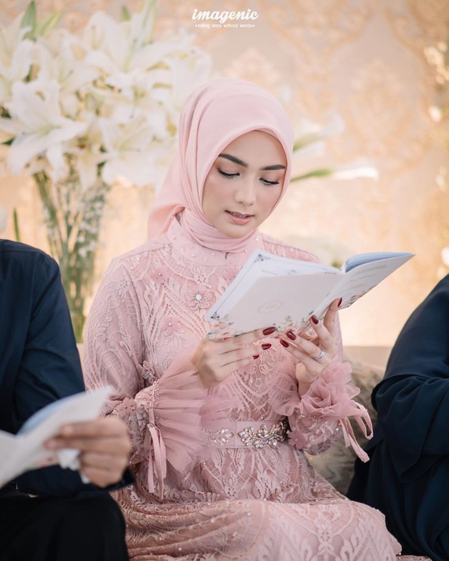 Saat pengajian, Citra Kirana tampil memesona dengan menggunakan hijab andalannya model segiempat warna pastel pink yang dililip rapi ke belakang dan dress brukat warna senada dari Elzatta. Ciki memang brand ambassador dari brand busana muslimah tersebut. Foto: instagram @imagenic