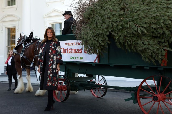 Sehari sebelumnya, Senin (25/11/2019), Melania Trump sempat menghadiri acara penyambutan pohon Natal di Gedung Putih. Pada kesempatan tersebut, coat hitam berhiaskan motif floral dari Dolce & Gabbana menjadi andalannya. (Foto: Getty Images)