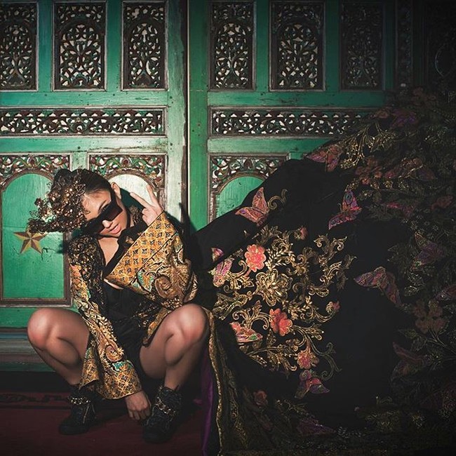 Jubah hitam beledu dengan motif bunga keemasan membuat penampilan Agnez Mo terlihat dramatis. Foto: Instagram/@agnezmo