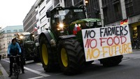 Sejumlah petani mengendarai traktor yang telah dipasangkan dengan berbagai spanduk maupun poster menuju ke pusat Kota Berlin untuk melakukan protes atas kebijakan pertanian pemerintah Jerman. Markus Schreiber/AP Photo.