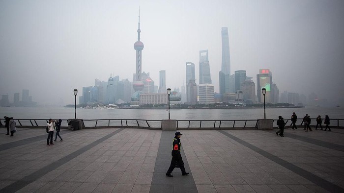 TOPSHOT - A security guard walks at the bund near the Huangpu river across the Pudong New Financial district, in Shanghai on January 18, 2016. China recorded its lowest growth in a quarter of a century in 2015, an AFP survey has forecast, projecting a further slowdown in the worlds second-largest economy this year.   AFP PHOTO / JOHANNES EISELE / AFP / JOHANNES EISELE        (Photo credit should read JOHANNES EISELE/AFP/Getty Images)