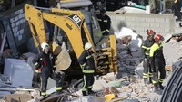 Alat berat juga dikerahkan untuk membantu petugas dalam melakukan proses evakuasi korban terdampak gempa tersebut. Visar Kryeziu/AP Photo.