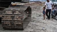Anak-anak yang penasaran dengan alat berat yang bekerja mencoba mendekat sambil ditemani orang tuanya.