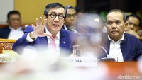 Yasonna menghadiri rapat dengan mengenakan jas berwarna biru.
