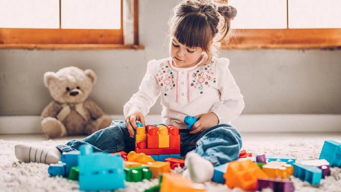 Sweet child playing with plastic blocks
