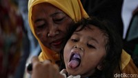 Seorang ibu bersama buah hatinya tengah memanfaatkan pemeriksaan kesehatan gratis.