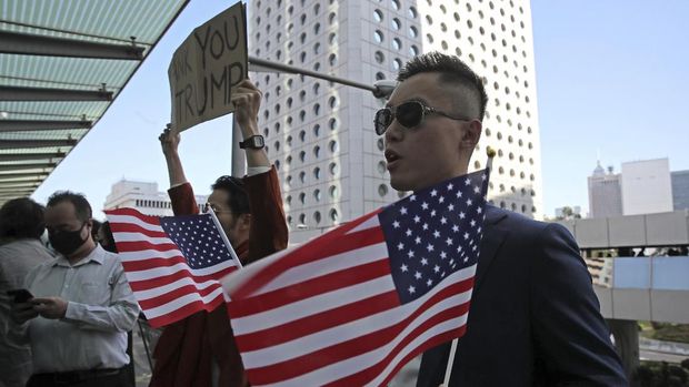 Demonstran Hong Kong membawa bendera AS dan poster bertuliskan ucapan terima kasih untuk Trump