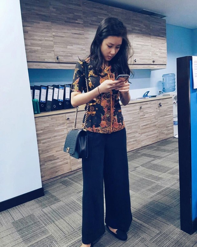 Karen pun mengenakan batik ketika bekerja. Penampilan kantorannya itu dilengkapi dengan tas bermerek. Foto: Instagram @karbearv
