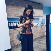 Karen pun mengenakan batik ketika bekerja. Penampilan kantorannya itu dilengkapi dengan tas bermerek. Foto: Instagram @karbearv