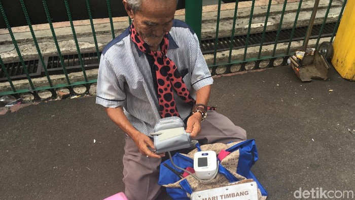 Kakek penjual jasa timbang badan dan ukur tensi di Stasiun Bogor (Foto: Nafila Sri Sagita K) Kakek penjual jasa timbang badan dan ukur tensi di Stasiun Bogor (Foto: Nafila Sri Sagita K)