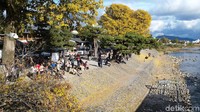 Para turis menikmati musim gugur di Kyoto, Jepang.