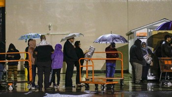 Tetap setia antre walau diguyur hujan. Foto: AP