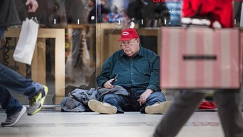 Seorang kakek-kakek tampak kelelahan menunggu toko buka. Foto: AP