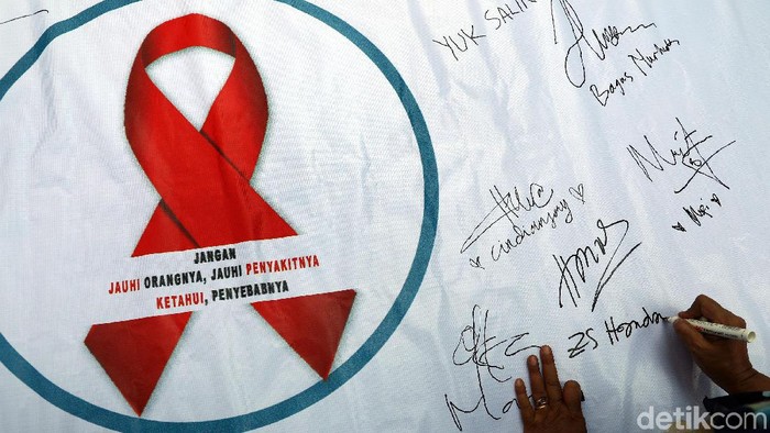 Sejumlah aktivis memperingati Hari AIDS Sedunia di kawasan Car Free Day, Bundaran HI, Jakarta, Minggu (1/12/2019). Mereka juga membagikan bungan dan poster kepada warga.