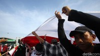Bendera merah putih berukuran besar dibentangkan di depan panggung utama.
