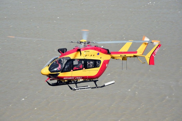 (FILES) In this file photo taken on May 05, 2015 A French Civilian Security EC145 helicopter flies next to Mont-Saint-Michel in Normandy during a large air evacuation drill, in order to test coordination of air assets in the event of a potential crisis scenario at the site. - Three emergency workers were killed in a helicopter crash near Marseille while on a rescue mission in southern France where floods have left two dead, officials said December 2, 2019. (Photo by Damien MEYER / AFP)