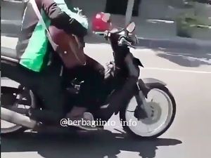 Abang Ojol Ini Pengamen Kali Ya, Main Gitar Kok Sambil Naik Motor