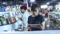 Sejumlah pengunjung sedang membaca buku di lokasi bazar.