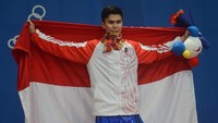 Atlet wushu Indonesia Edgar Xavier Marvelo menggigit medali setelah memenangi nomor Wushu Gunshu Putra SEA Games 2019. ANTARA FOTO/Nyoman Budhiana.