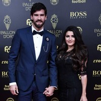 Kiper Liverpool Alisson Becker menghadiri Ballon dOr bersama istrinya, Natalia Loewe Becker. Natalia Loewe Becker yang merupakan seorang dokter itu tampil memesona dengan rambut ikal panjangnya yang digerai dan memakai gaun hitam dengan detail transparan di bagian kaki. Foto: Anne-Christine POUJOULAT / AFP