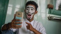 Seorang penyintas disabilitas tuna rungu berbicara menggunakan bahasa isyarat lewat ponsel saat acara Belajar Pantomim Bersama di SLB Negeri Solo, Jawa Tengah, Selasa (3/12/2019). Antara Foto/Mohammad Ayudha.