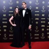 Pemain Liverpool lainnya yang juga hadir di pesta Ballon dOr adalah Virgil van Dijk. Virgil termasuk salah satu kandidat pemenang Ballon dOr. Dia pun didampingi istrinya Rike Nooitgedagt yang memesona. Rike yang rela meninggalkan pekerjaannya di dunia fashion demi mengikuti karier suami tampil elegan dengan gaun hitam simpel yang panjangnya menyapu lantai. Foto: Anne-Christine POUJOULAT / AFP
