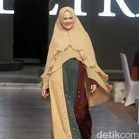 Cut Meyriska berlenggang bak model dengan abaya coklat hijau. Khimar dengan keliman bergaya ruffle menyumbangkan kesan feminin pada penampilannya. Foto: Mohammad Abduh/Wolipop