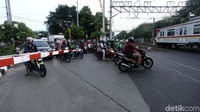 Sejumlah pemotor nampak menerobos palang kereta api saat menunggu kereta melintas di Jalan Jalan Industri Raya, Gunung Sahari, Jakarta. Rabu (4/12/2019).