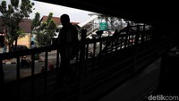 Seorang warga melintas di samping pagar yang patah ditabrak truk.