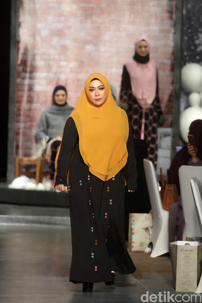 Penampilan para selebriti lalu ditutup dengan kemunculan Melly Goeslaw. Abaya hitam yang dihiasi bolongan warna-warni sebagai aksen menjadi andalan musisi ini. Foto: Mohammad Abduh/Wolipop