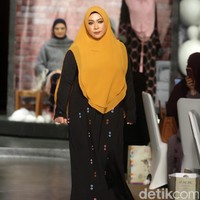 Penampilan para selebriti lalu ditutup dengan kemunculan Melly Goeslaw. Abaya hitam yang dihiasi bolongan warna-warni sebagai aksen menjadi andalan musisi ini. Foto: Mohammad Abduh/Wolipop