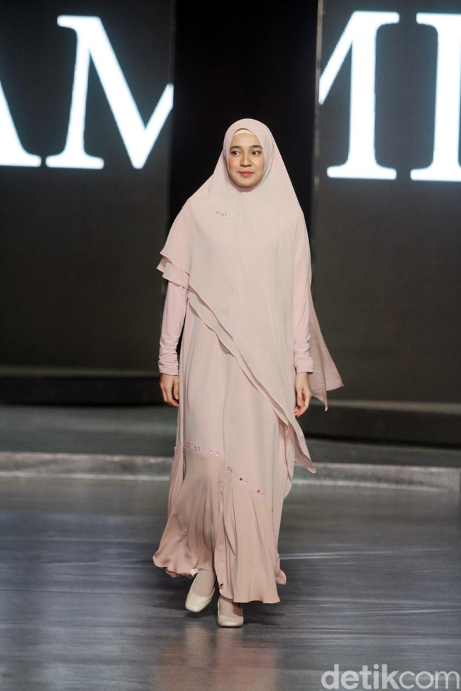 Muncul pula Dhini Aminarti, juga dengan baju syar’i polos pastel khas brand yang eksis sejak 2011 tersebut. Khimar tumpuk bergaya asimetris menjadi daya tarik tersendiri dari penampilannya. Foto: Mohammad Abduh/Wolipop
