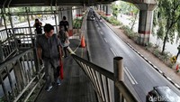 Sejumlah warga melintas di JPO Bea Cukai yang rusak ditabrak truk kontainer.