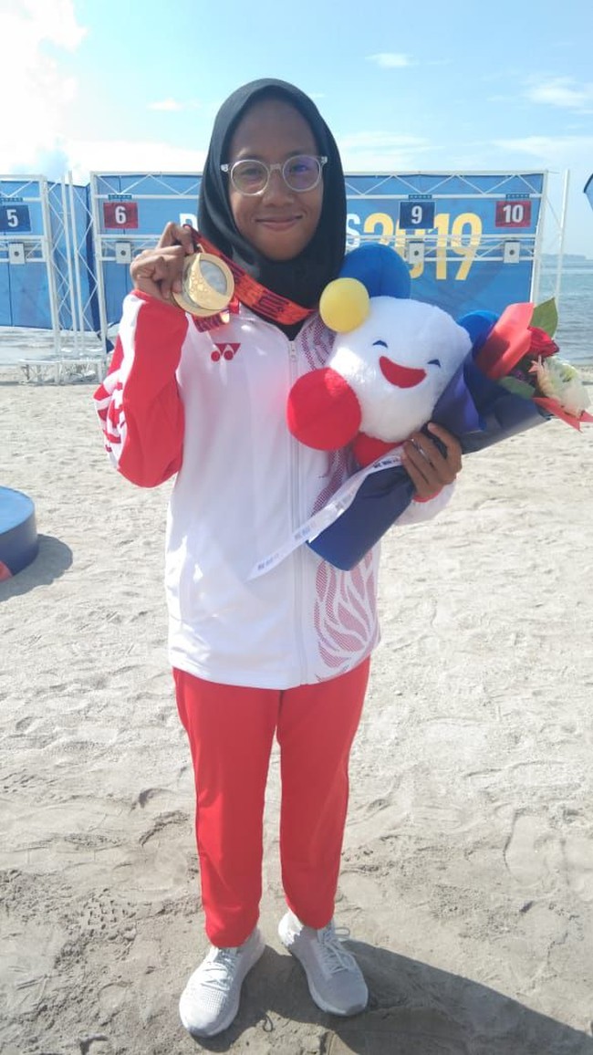 Dea Salsabila merupakan atlet berhijab yang meraih emas dalam PON XX PAPUA 2021. Dea berhasil menjadi yang tercepat dengan catatan waktu 41 menit 8 detik, dalam cabor renang perairan terbuka nomor 3.000 meter. Ia berhasil mengungguli enam lawannya yang berasal dari sejumlah provinsi di Indonesia di nomor tersebut. Foto: dok. NOC.