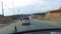 Namun, saat ini tol tersebut belum bisa dinikmati masyarakat karena belum dibuka umum. Akses menuju jalan tol tersebut masih ditutup. Petunjuk arah menuju jalan tol pun masih tertutup kain. Jadi, kami harus melewati jalan non-tol. Foto: Rangga Rahardiansyah/detikOto