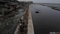 Sejumlah warga beraktivitas di kawasan tanggul laut Muara Baru, Jakarta Utara, Jumat (6/12).