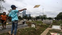Anak-anak tersebut bermain layang-layang bersama teman sebayanya.